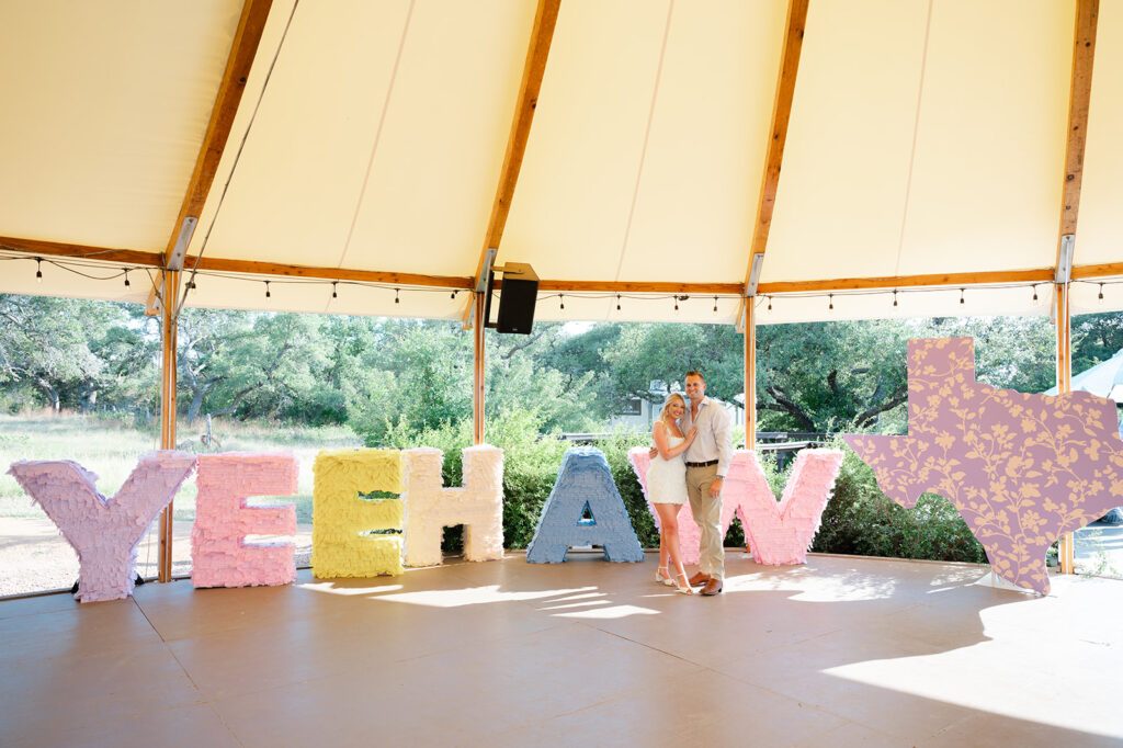 photo ops for your wedding reception rentals couple standing in front of a "Yeehaw" sign