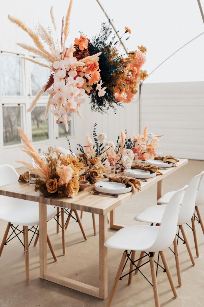 a soft, subtle sunset wedding color palette used in floral arrangements on a white table
